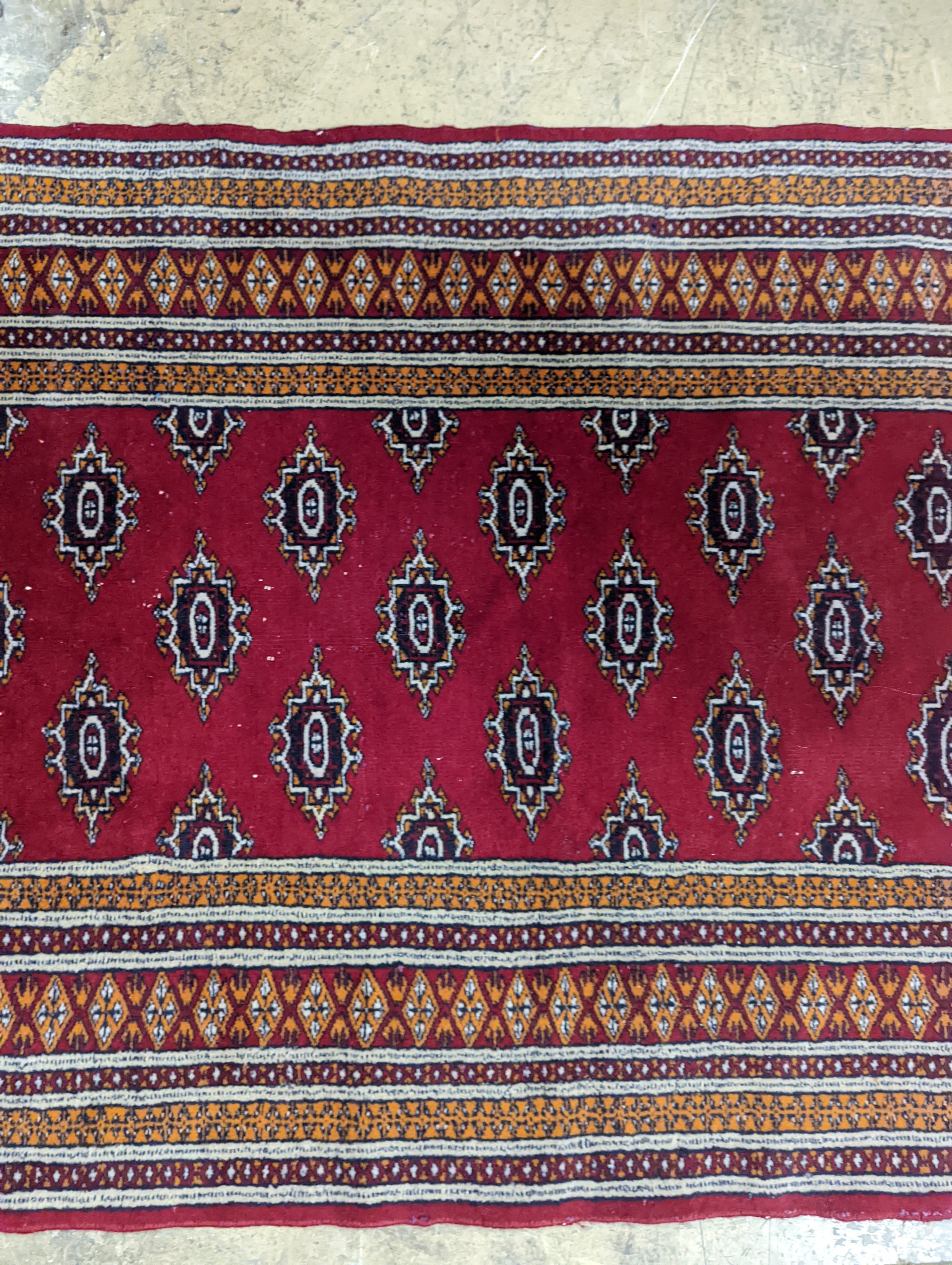 A Bokhara red ground rug, 155 x 88cm